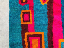 Load image into Gallery viewer, Vividly colored section of a Moroccan rug with square patterns, seen up close to show the plush pile and weave.
