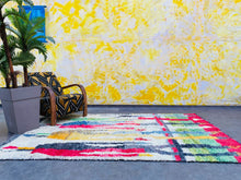 Load image into Gallery viewer, The Colorful Berber rug placed in a bright room, with its lively patterns adding character and warmth to the living space.

