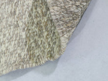 Load image into Gallery viewer, Detailed view of a Beni Ourain carpet featuring bold black tribal designs on a thick white wool pile


