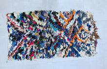 Load image into Gallery viewer, Close-up of the colorful patchwork design on a Moroccan Boucherouite rug.
