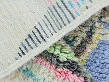 Load image into Gallery viewer, Full view of a pastel Moroccan wool rug with artistic designs.
