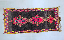 Load image into Gallery viewer, Close-up of vibrant pink and black design on rug.
