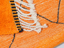Load image into Gallery viewer, Eye-catching Moroccan wool rug in vivid orange with tribal black designs, adds a unique touch to living rooms or studios.


