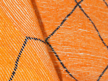 Load image into Gallery viewer, Authentic Moroccan shag rug in orange with minimalist black patterns, great for bohemian bedrooms or artistic spaces.


