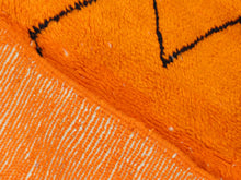 Load image into Gallery viewer, Soft shaggy wool rug in a bold orange tone, handmade in Morocco with a modern tribal geometric design.


