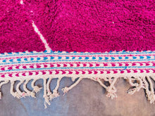 Load image into Gallery viewer, Segment of a Moroccan rug showing the edge and fringe design with a blend of colorful threads.
