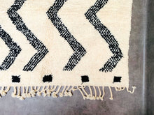 Load image into Gallery viewer, Detailed view of a Beni Ourain Moroccan rug&#39;s fringe, featuring alternating black and white patterns at the border, embodying traditional Berber aesthetics.
