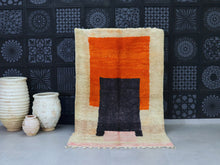 Load image into Gallery viewer, Handwoven Moroccan wool rug with bold orange and black geometric design.
