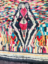 Load image into Gallery viewer, Close-up of a Moroccan wool rug&#39;s intricate pattern with vivid pink, blue, and orange hues on a white background
