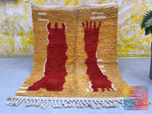 Load image into Gallery viewer, Overhead shot of a Moroccan wool rug featuring bold red designs on a yellow field, with a grey concrete floor as backdrop.
