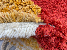 Load image into Gallery viewer, Textural close-up of a Moroccan wool rug&#39;s fringe, with alternating bands of yellow, red, and white fibers.
