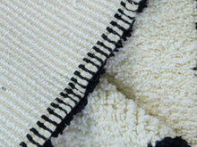 Load image into Gallery viewer, Close-up of cream wool rug with small black details.
