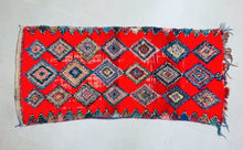 Load image into Gallery viewer, Close-up of the bold diamond patterns on a red rug.
