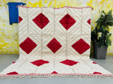 Load image into Gallery viewer, Traditional Moroccan Berber Beni Ourain rug with vibrant red diamonds pattern against a creamy white pile, displayed vertically in a bohemian-style room
