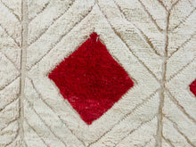 Load image into Gallery viewer, Zoomed-in detail of a red diamond motif on a white Berber Beni Ourain rug, showcasing the plush texture and traditional Moroccan design.
