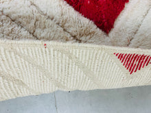 Load image into Gallery viewer, Edge detail of a Moroccan Beni Ourain rug with red diamond accents, highlighting the sturdy construction and fringe edging
