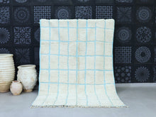 Load image into Gallery viewer, Minimalist Moroccan wool rug with a soft blue grid design.
