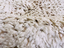 Load image into Gallery viewer, Close-up of the intricate weave of a handmade Berber rug, highlighting the soft texture and quality of a washable, authentic Moroccan wool.
