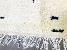 Load image into Gallery viewer, Close-up of a Moroccan wool rug’s fringe, highlighting the handwoven craftsmanship and playful color splashes.
