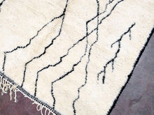 Load image into Gallery viewer, Close-up of the thick pile and hand-knotted patterns of a Moroccan Beni Ourain rug, a testament to craftsmanship
